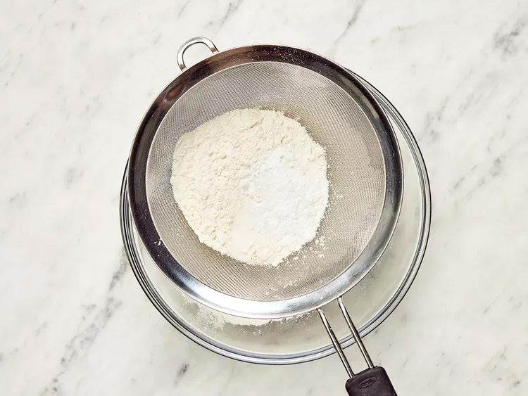 Flour being sifted into bowl